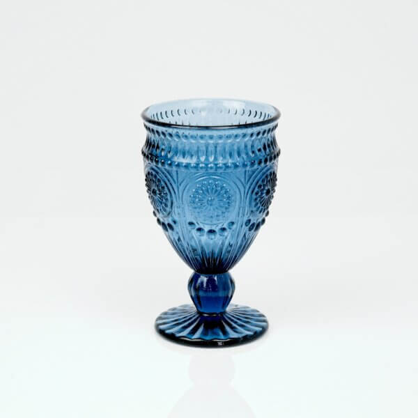 Blue glass vintage style goblet sitting on white background.