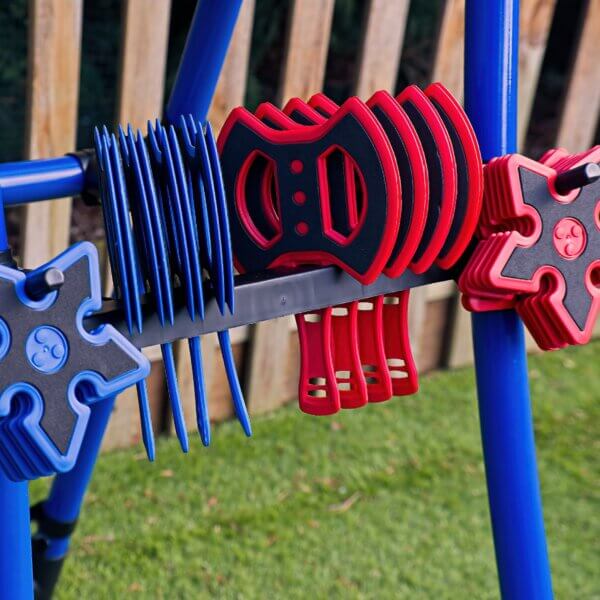 Close up of blue and red plastic axes and stars, resting in their mounting holes on the A frame of the Axe Throwing target.