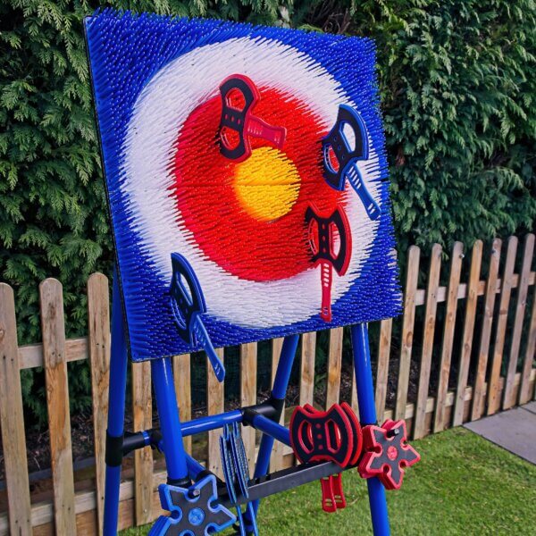 Close up of blue and red plastic axes and stars, resting in their mounting holes on the A frame of the Axe Throwing target.