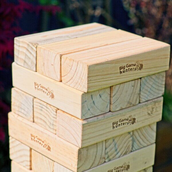 A close up of the top few rows of a Giant Jenga tower. 5 rows of 3 bricks are visible. Each row at 90 degrees to the previous row.