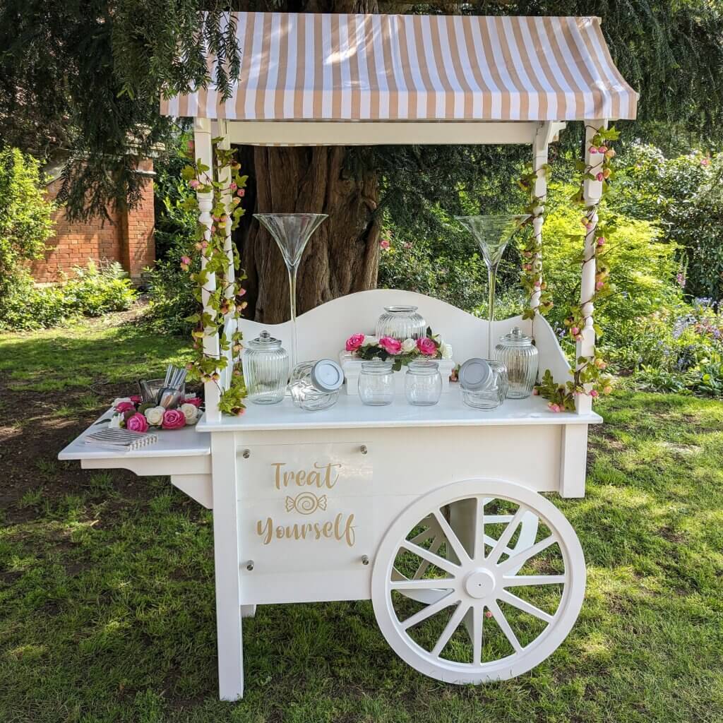 Elegant sweet cart with a gold and white canopy, complete with sweet bags and a decorative sign, perfect for weddings and parties.