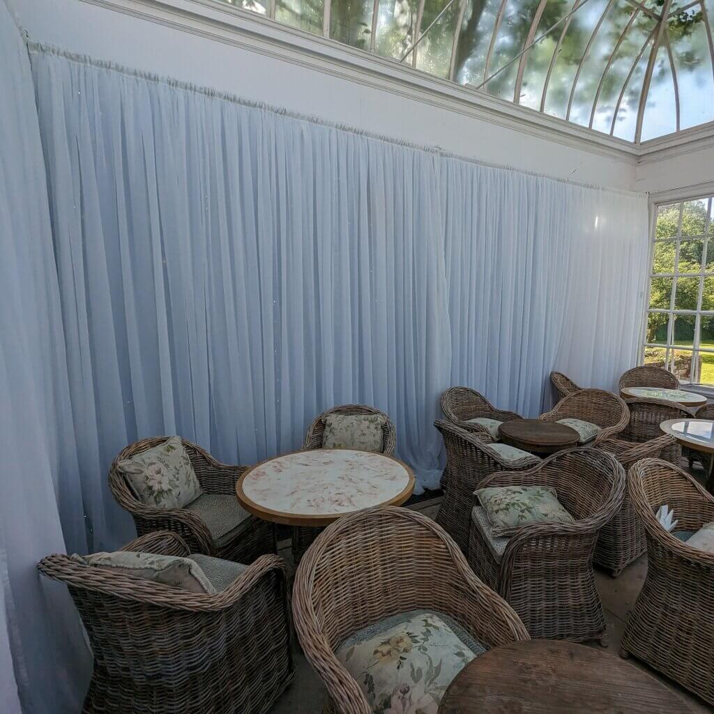 6m of white drape backdrop covering two walls of conservatory at Norton Park Hotel