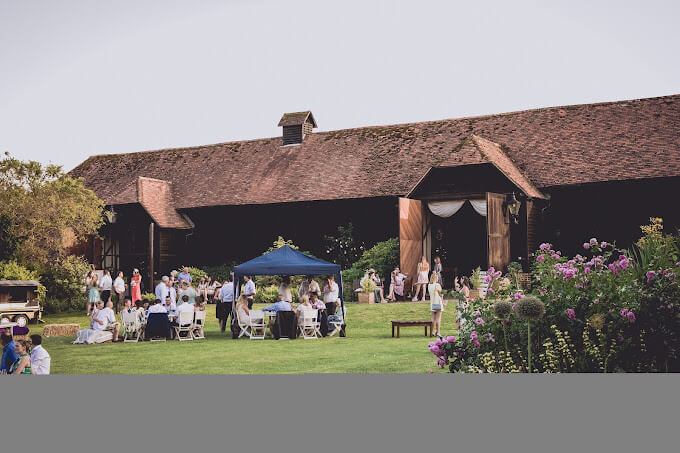 Hillfields Farm in Pangbourne. The outside of the large barn is on display with guests using the outside garden