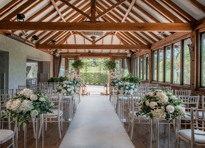 The Old Thorns in Liphook, Hampshire. Rows of chairs sewtup either side of an aisle to show off this ceremony setup with oak beams above.