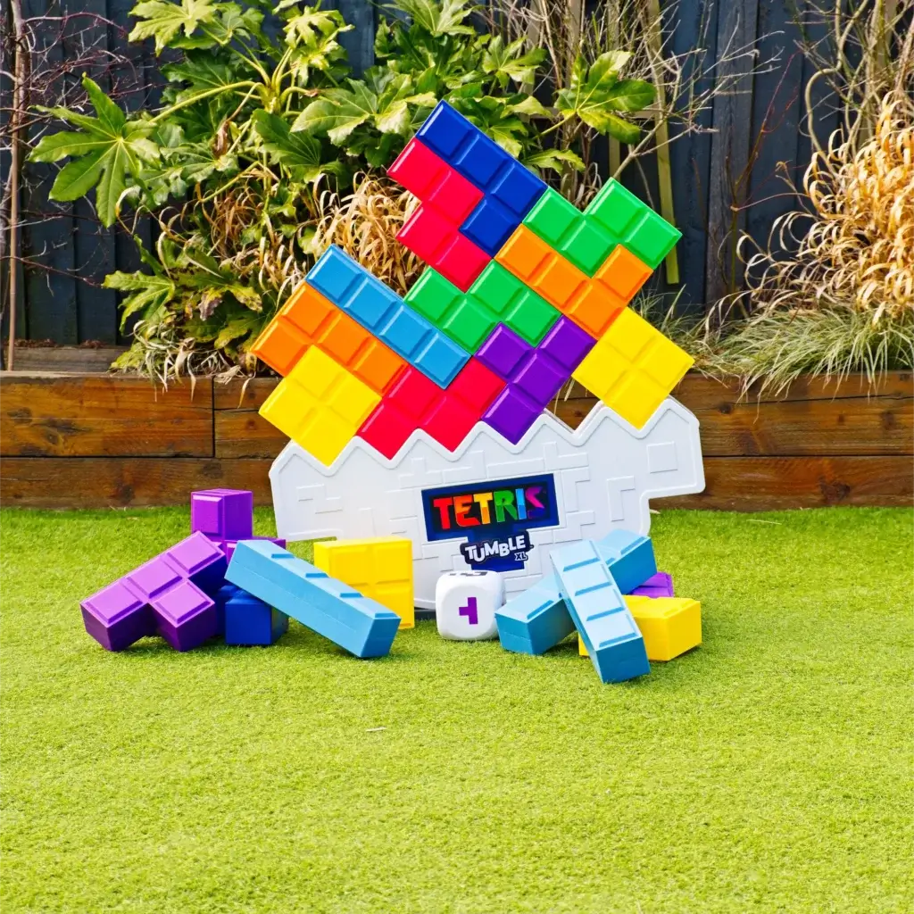 Tetris Tumble XL garden game hire with colours tetris shapes, balancing on wobbly base