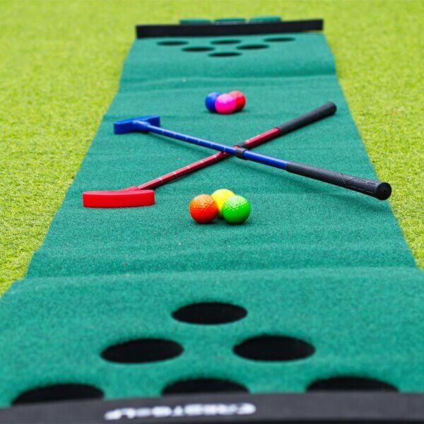 Golf pong mat with 6 putting holes on either end. A blue and red adjustable putters and 6 coloured golf balls sit on the mat.