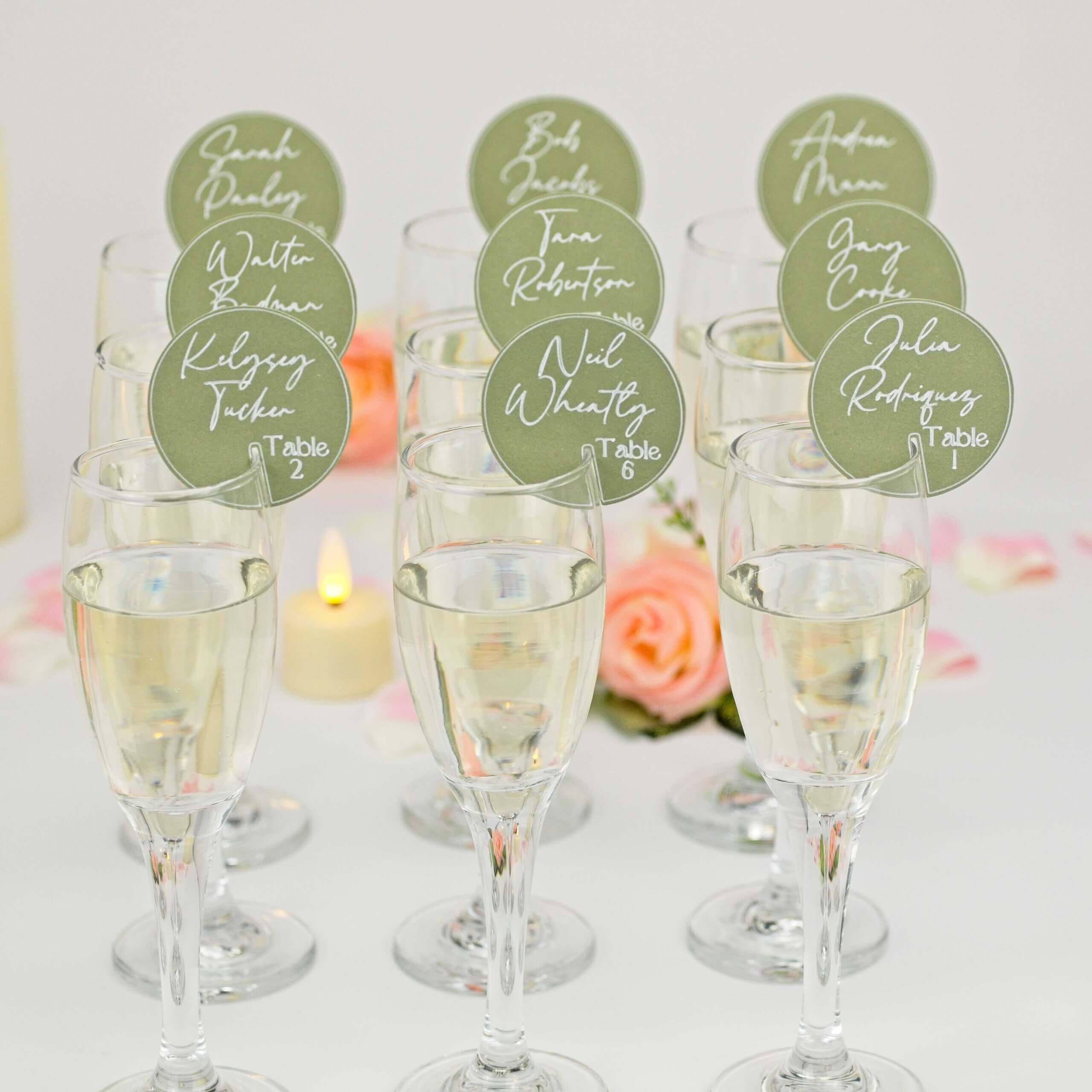 Rows of champagne glasses each with green circular place tag