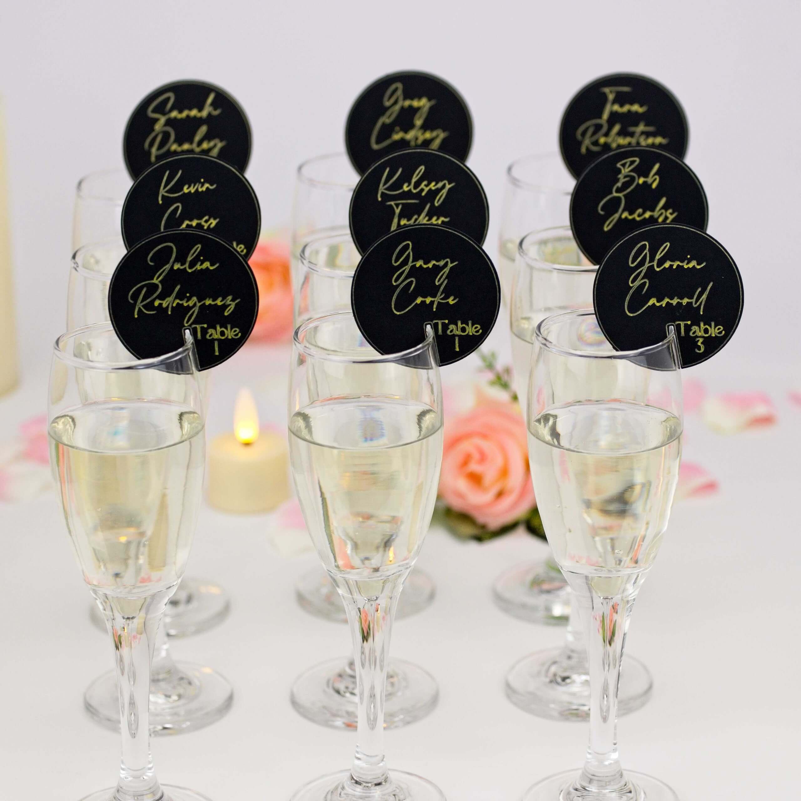 Front group shot of champagne glasses topped with black place tags